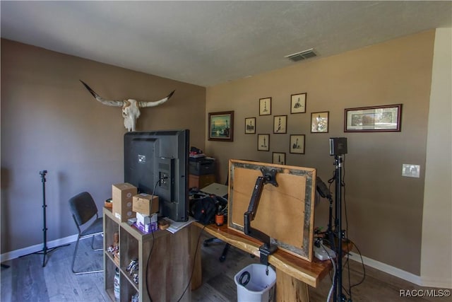 office featuring baseboards, visible vents, and wood finished floors