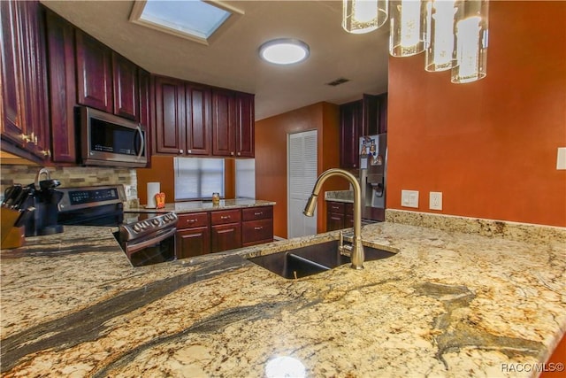 kitchen with reddish brown cabinets, appliances with stainless steel finishes, a sink, and visible vents