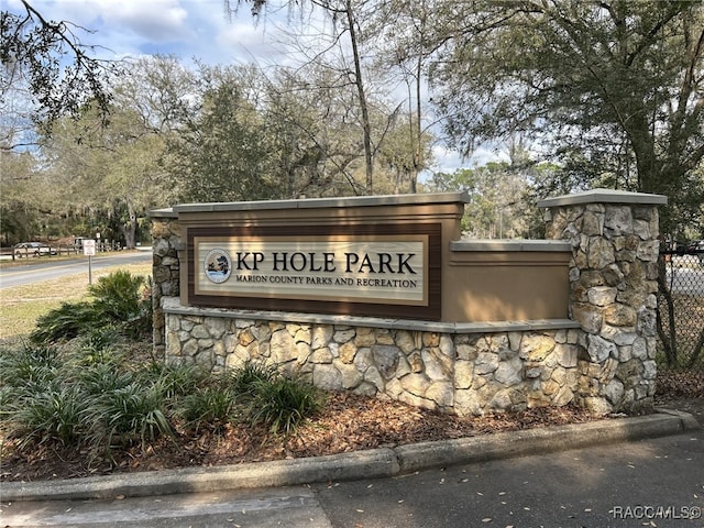 community / neighborhood sign featuring fence