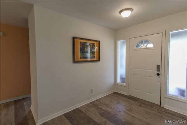 foyer featuring dark wood finished floors and baseboards