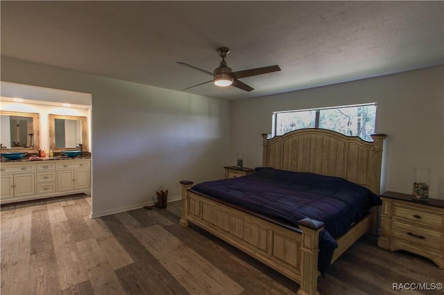 bedroom with ensuite bathroom, ceiling fan, wood finished floors, and baseboards