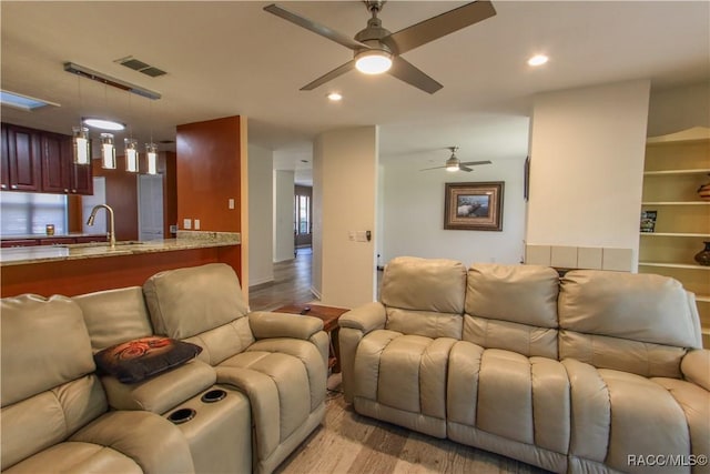 living room with light wood-style floors, recessed lighting, visible vents, and ceiling fan