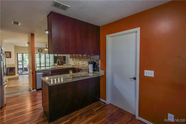 kitchen with visible vents, decorative backsplash, dark wood-style floors, appliances with stainless steel finishes, and a peninsula