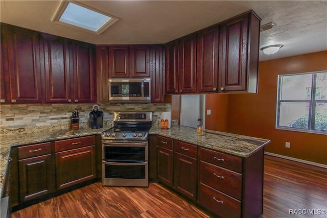 kitchen with reddish brown cabinets, appliances with stainless steel finishes, and dark wood finished floors