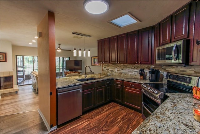 kitchen featuring reddish brown cabinets, dark wood finished floors, stainless steel appliances, and a sink