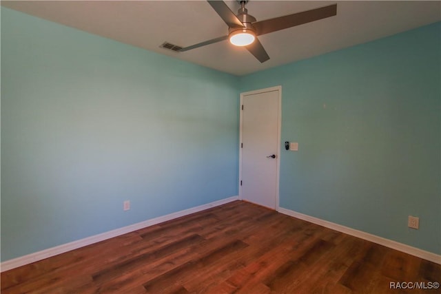 spare room with ceiling fan, wood finished floors, visible vents, and baseboards