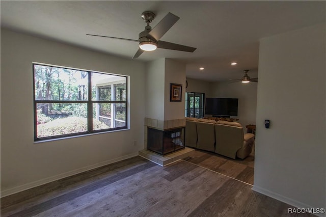 unfurnished living room featuring recessed lighting, baseboards, wood finished floors, and a tile fireplace