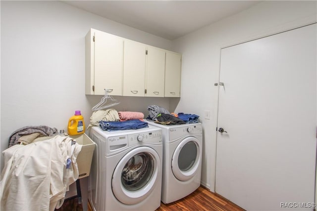 washroom with dark wood-style flooring, independent washer and dryer, and cabinet space