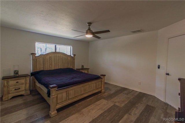 bedroom with dark wood-style floors, ceiling fan, visible vents, and baseboards