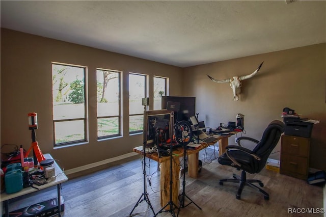 office featuring a textured ceiling, baseboards, and wood finished floors