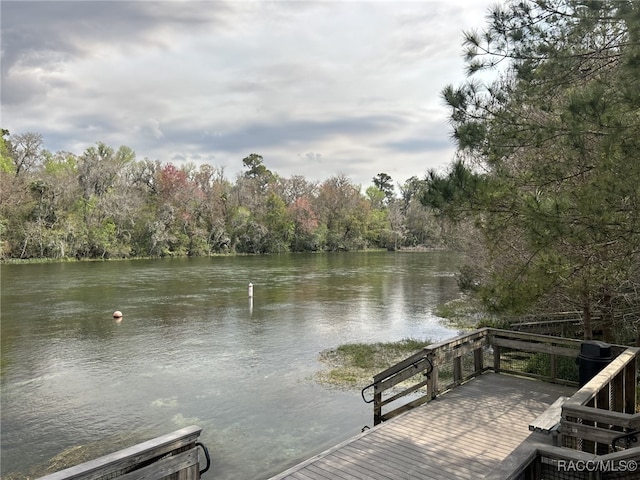 view of dock with a forest view and a water view