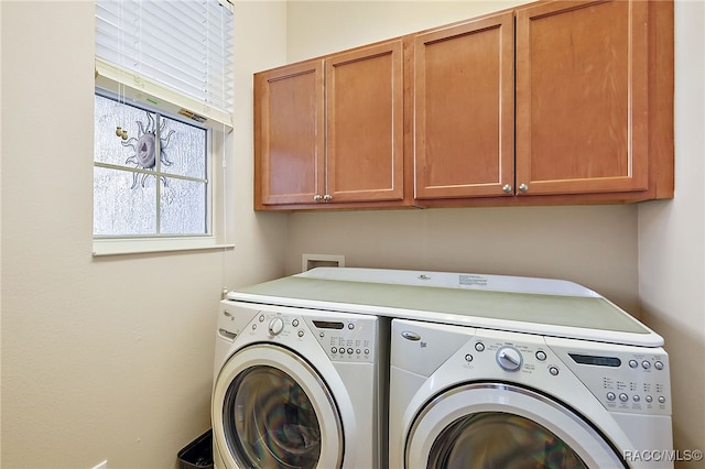 laundry room with washer and dryer and cabinets