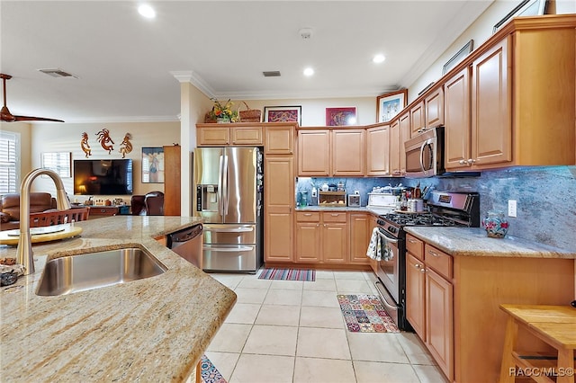 kitchen with light stone countertops, sink, stainless steel appliances, backsplash, and crown molding