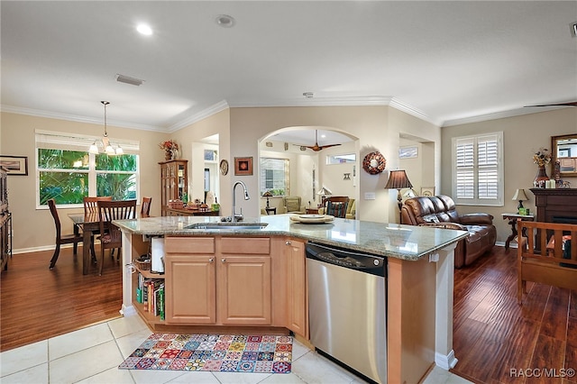 kitchen featuring dishwasher, a healthy amount of sunlight, a center island with sink, sink, and light hardwood / wood-style floors