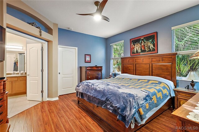 bedroom featuring connected bathroom, ceiling fan, and light hardwood / wood-style flooring