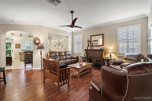 living room with ceiling fan, ornamental molding, and dark wood-type flooring