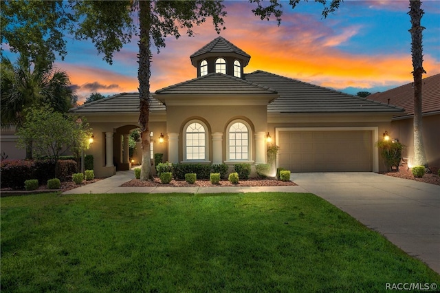 view of front of home with a garage and a yard