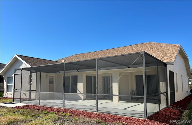 rear view of house with a lanai and a patio area