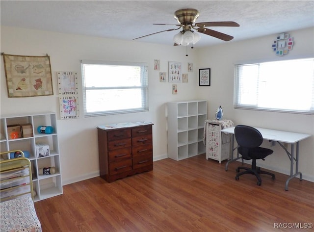 home office with ceiling fan, dark hardwood / wood-style flooring, and a textured ceiling