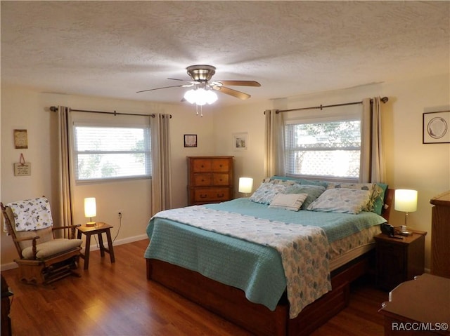 bedroom with hardwood / wood-style floors, a textured ceiling, and ceiling fan