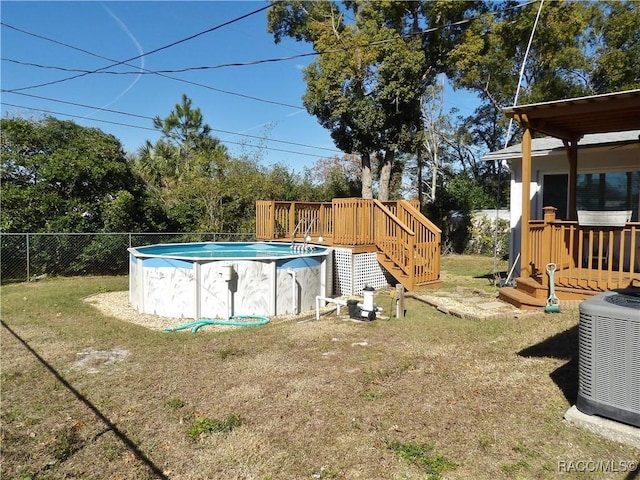 view of swimming pool featuring cooling unit, a yard, and a deck