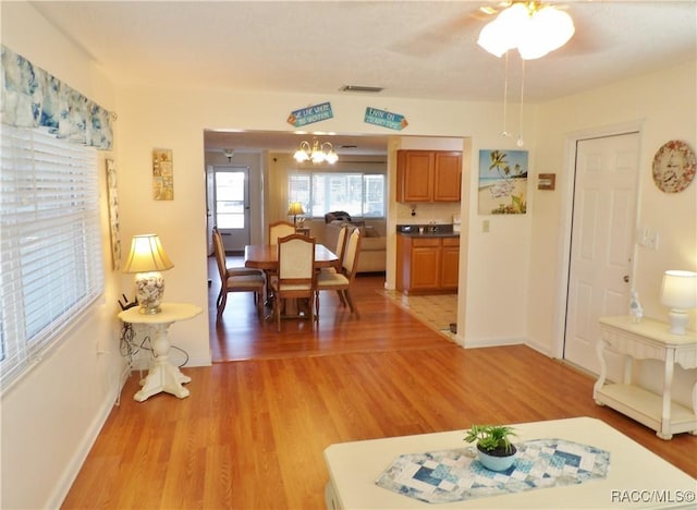 dining room with light hardwood / wood-style flooring and a notable chandelier