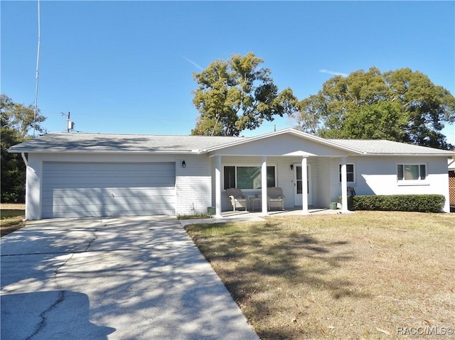 single story home featuring a garage, covered porch, and a front lawn