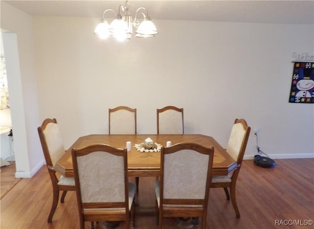 dining space featuring hardwood / wood-style floors and an inviting chandelier