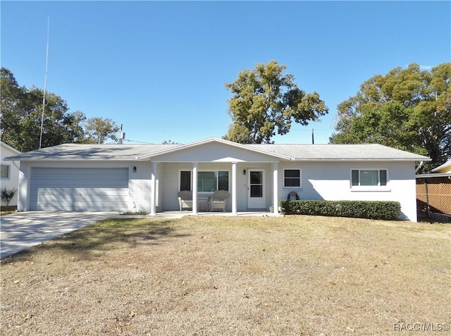 ranch-style house featuring a porch, a garage, and a front lawn