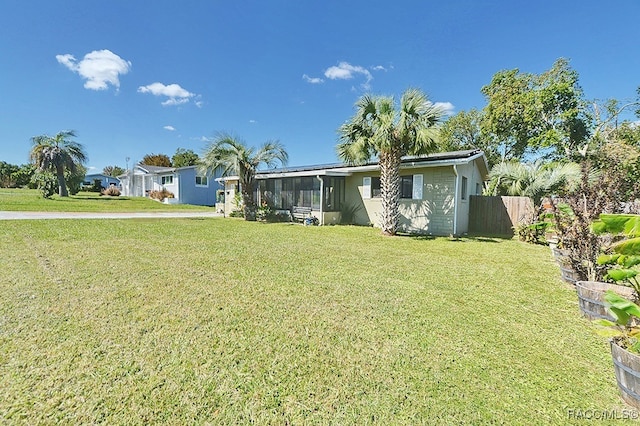 view of front facade featuring a sunroom and a front lawn