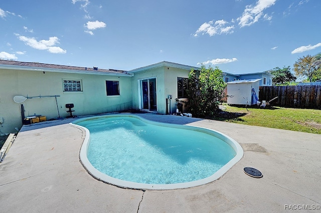 view of pool with a patio area and a lawn