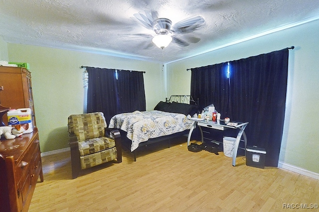 bedroom featuring hardwood / wood-style floors, ceiling fan, and a textured ceiling