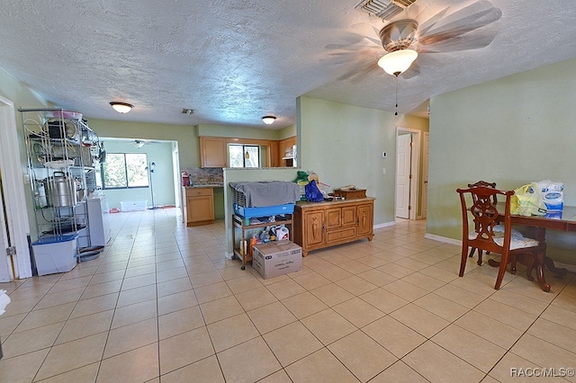 kitchen with backsplash, ceiling fan, light tile patterned floors, and a textured ceiling