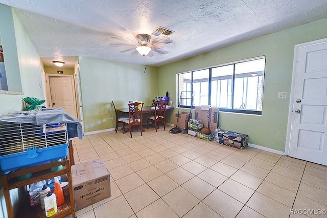 tiled dining area featuring a textured ceiling and ceiling fan