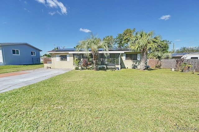 view of front of property featuring a front lawn and solar panels