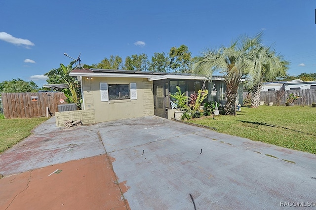 view of front of home featuring a front yard and a sunroom