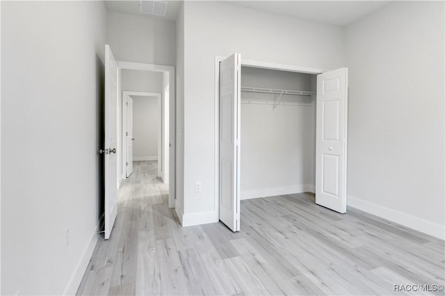 unfurnished bedroom with a closet and light hardwood / wood-style floors