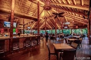 dining room with vaulted ceiling with beams, dark hardwood / wood-style floors, ceiling fan, and wood ceiling