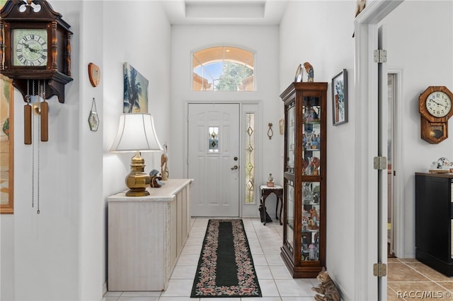 foyer entrance featuring a towering ceiling and light tile patterned flooring