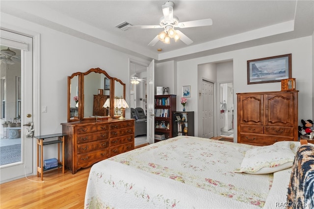 bedroom with ceiling fan, light hardwood / wood-style floors, and ensuite bath