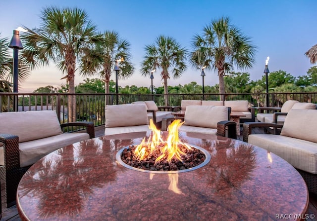 patio terrace at dusk with an outdoor living space with a fire pit