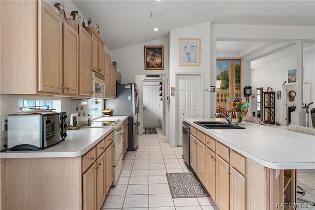 kitchen featuring light tile patterned flooring, appliances with stainless steel finishes, a breakfast bar, sink, and an island with sink