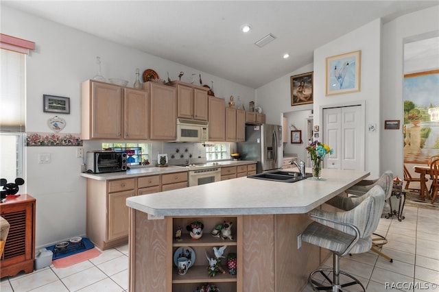 kitchen featuring a kitchen breakfast bar, white appliances, plenty of natural light, and lofted ceiling