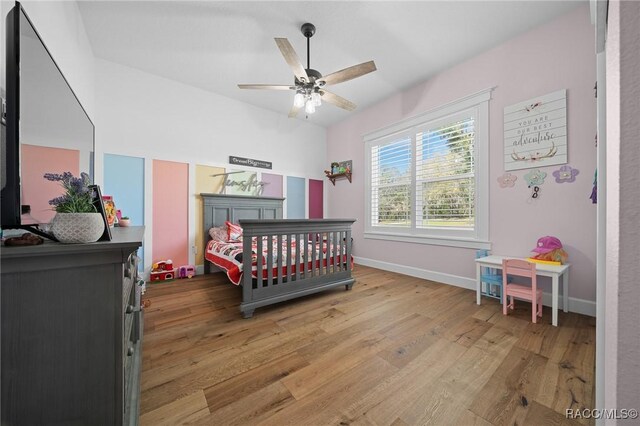 bedroom with wood finished floors, a ceiling fan, and baseboards