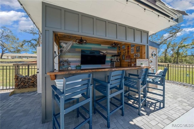 view of patio with a bar and fence