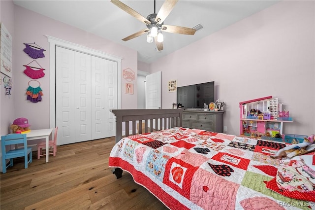 bedroom with a closet, visible vents, ceiling fan, and wood finished floors