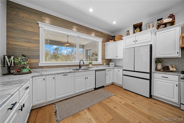 kitchen with dishwashing machine, light wood-style flooring, white fridge, white cabinetry, and a sink