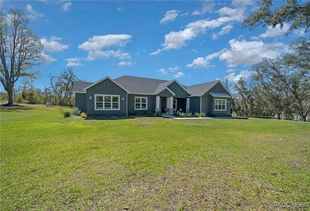 ranch-style home with board and batten siding and a front lawn