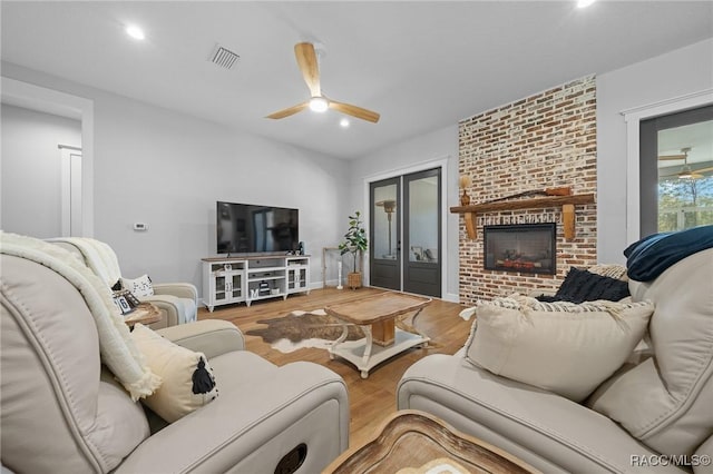 living room with ceiling fan, recessed lighting, a fireplace, wood finished floors, and visible vents