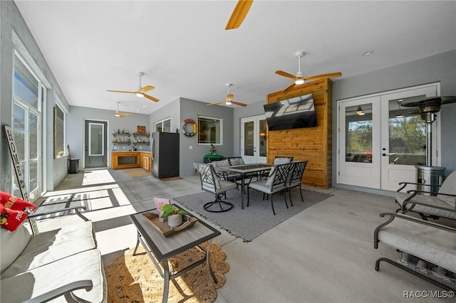 view of patio with a ceiling fan, outdoor dining space, and french doors